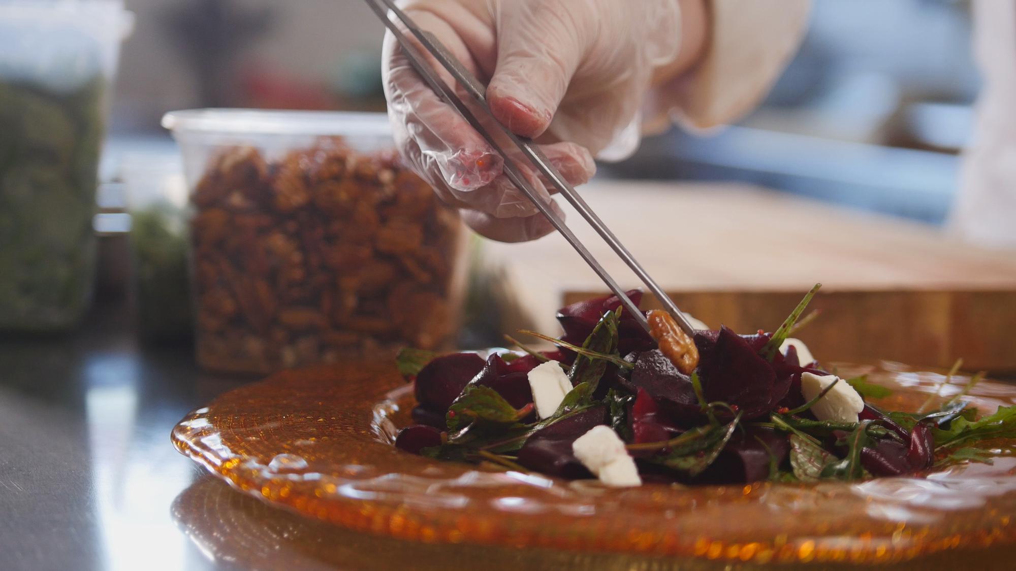 Hands preparing fine dining garnish on plate
